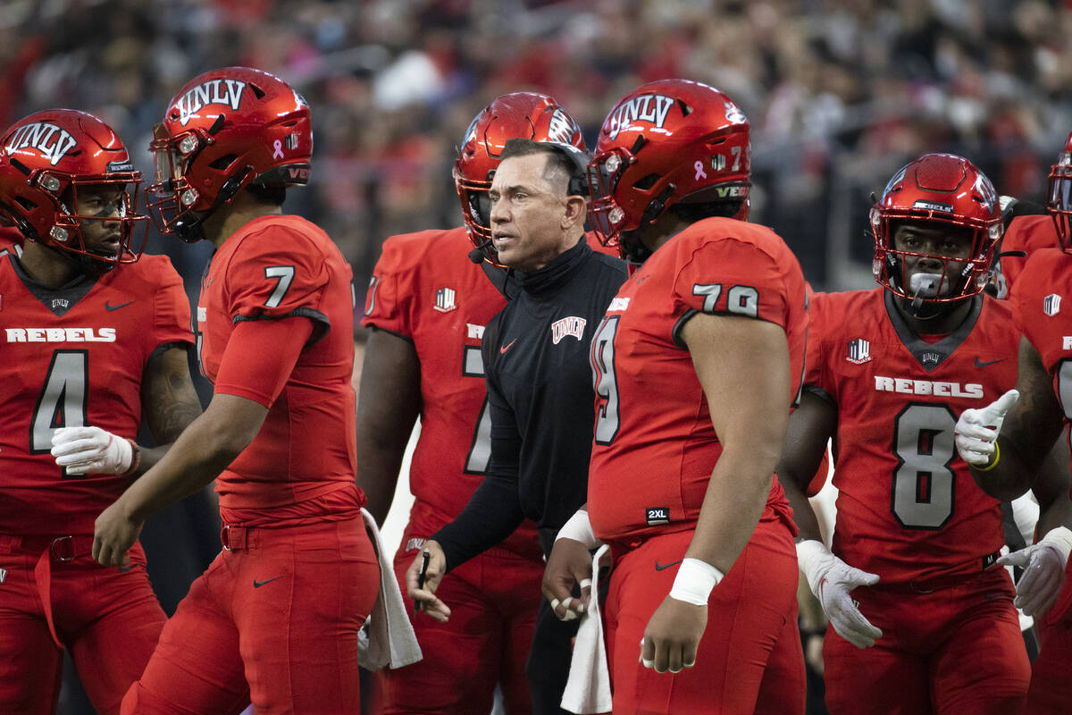 UNLV Rebels head coach Marcus Arroyo, middle, gives direction to his team during a time out in ...